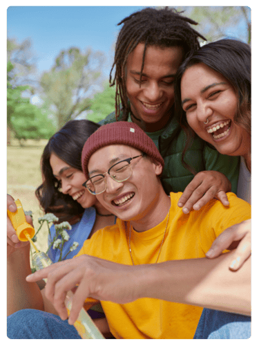 diverse group of teenagers laughing in a park